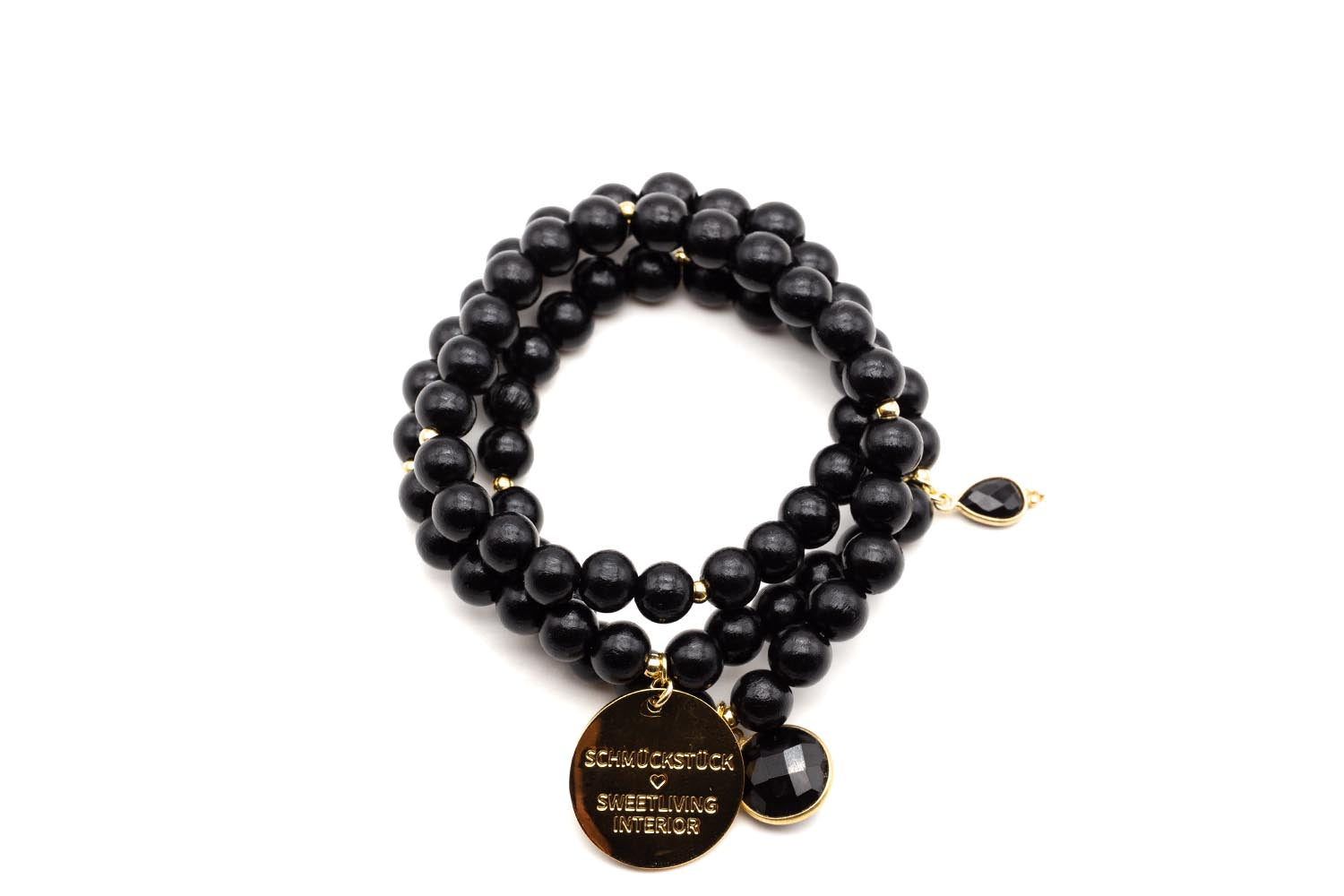Dreifach gewickeltes Armband aus schwarzen Holzperlen mit vergoldetem Logo-Tag und facettiertem Onyx-Anhänger