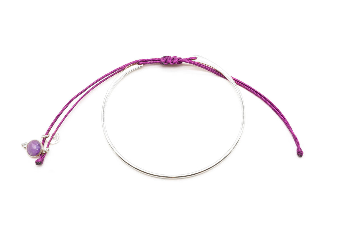 Armreif in silberfarbener Ausführung mit lila Macramé-Band und Amethyst-Anhänger, freigestellt