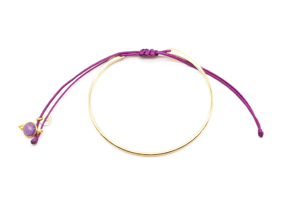 Vergoldeter Armreif mit lila geflochtenem Macramé-Band und Amethyst-Anhänger, freigestellt