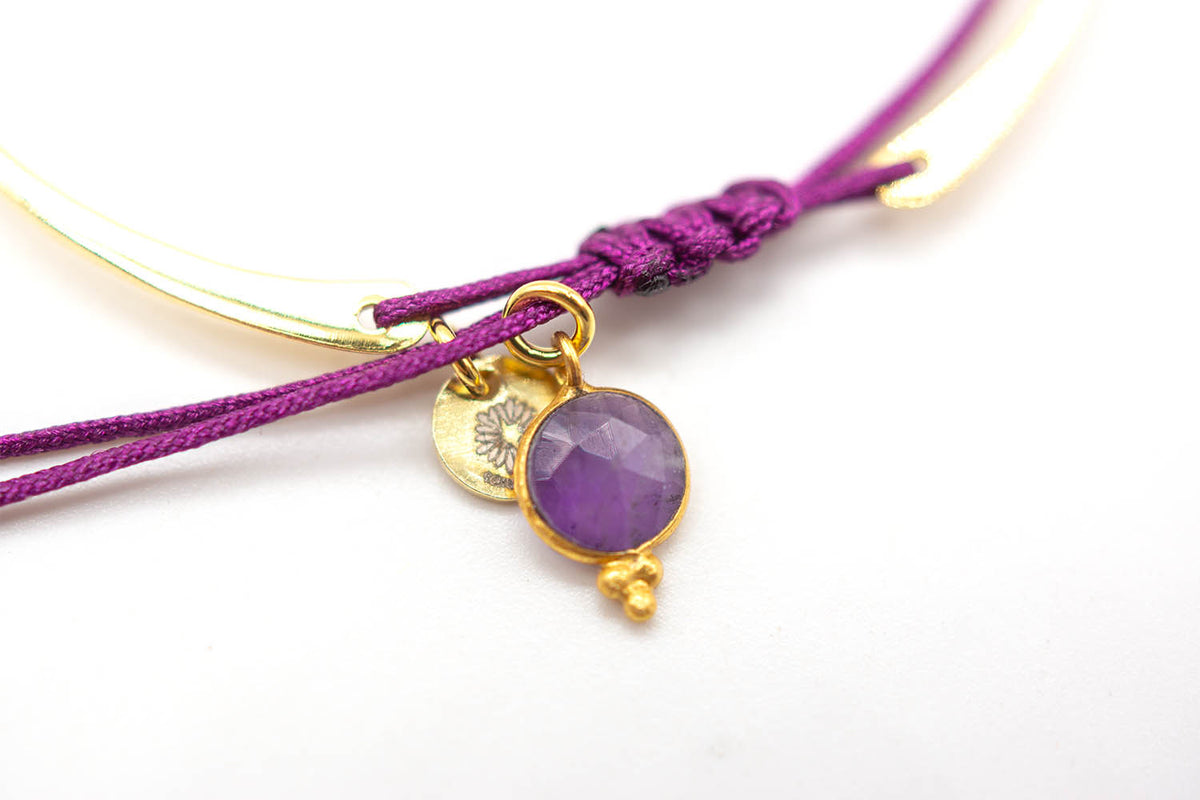 Detailaufnahme des Amethyst-Anhängers mit floral gestempeltem Plättchen am lila Band