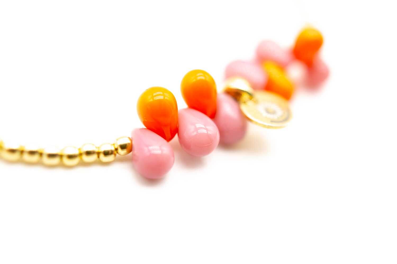 Detailaufnahme der rosa und orangefarbenen Tropfen mit rundem Anhänger