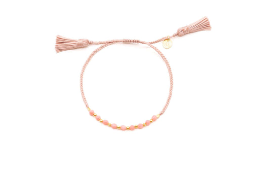 Geflochtenes Macramé-Armband in Rosé mit Korallenperlen, vergoldeten Kügelchen und zwei Quasten