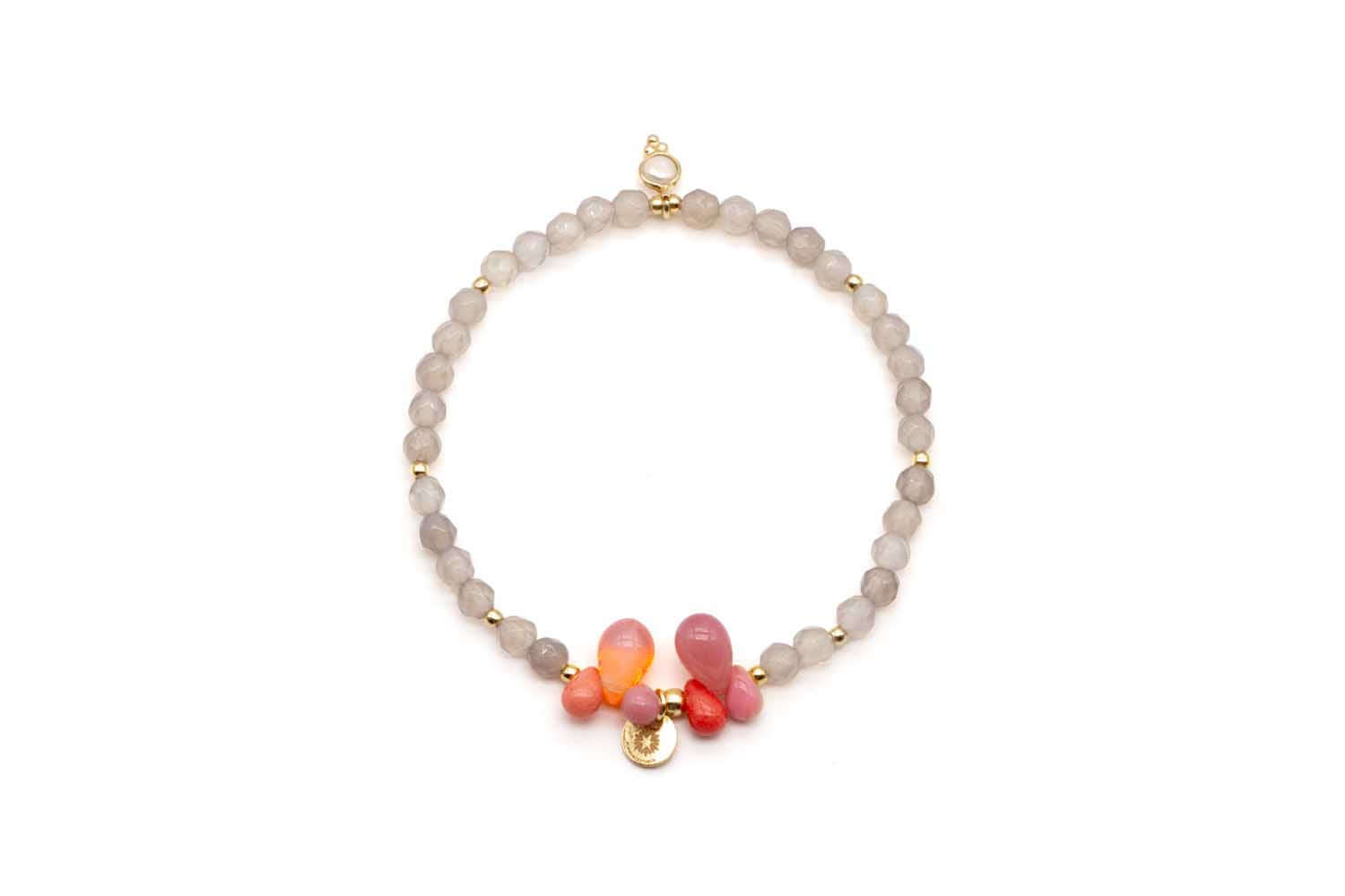 Armband auf Elastikband aus grauen Achatperlen mit rosa und orangefarbenen Tropfen und goldfarbenem Anhänger