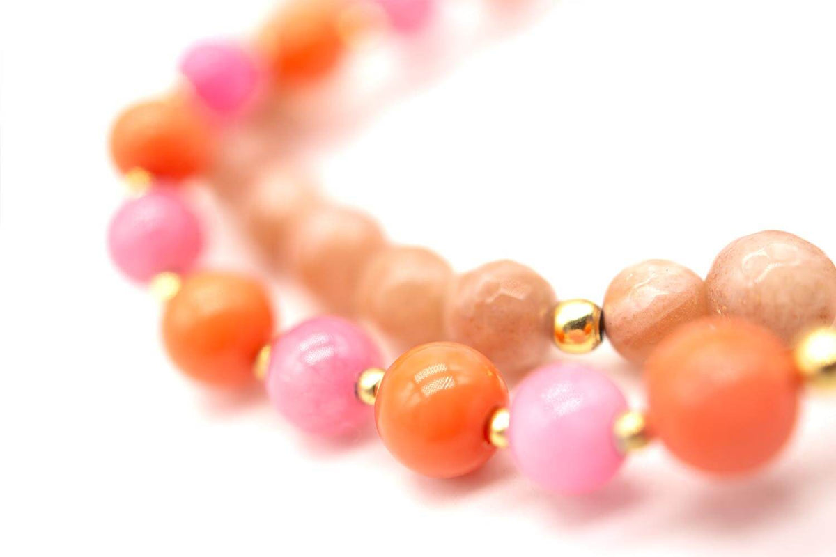 Detailaufnahme der rosa, orangefarbenen und beigefarbenen Perlen mit vergoldeten Zwischenperlen