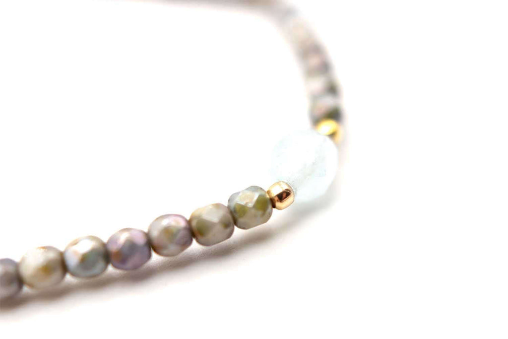 Detail der grau schimmernden Perlen mit Aquamarin-Perle und vergoldeter Perle