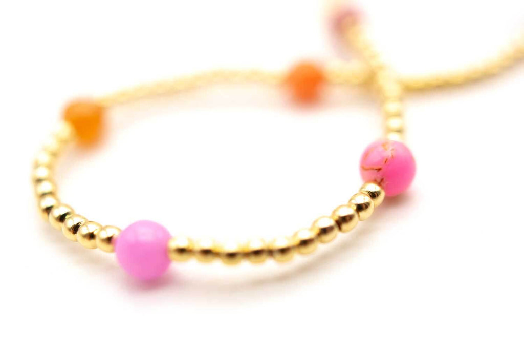 Detail der vergoldeten Perlen mit pink- und orangefarbenen Edelsteinperlen