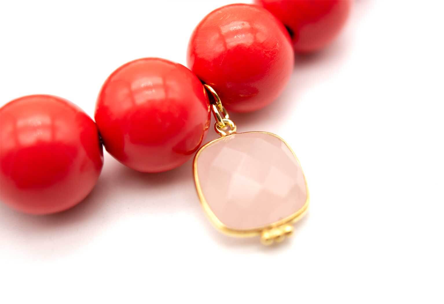 Detailaufnahme des quadratischen, milchig-rosa schimmernden Rosenquarz-Anhängers in vergoldeter Fassung