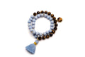 Doppelmala-Armband mit hellblauen Holzperlen, braunen Tigerauge-Perlen und blauer Quaste, freigestellt