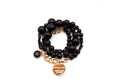 Dreifaches Armband aus schwarzen Perlen mit vergoldeter Curb-Kette, Onyx-Anhänger und rundem Logo-Tag