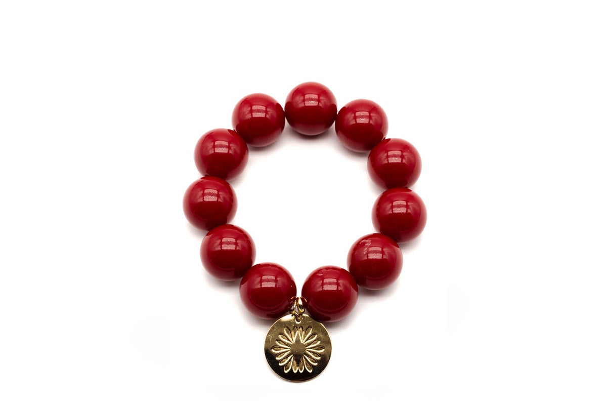 Armband auf Elastikband mit großen kirschroten Acrylperlen und vergoldetem Logo-Tag mit Blütenmotiv