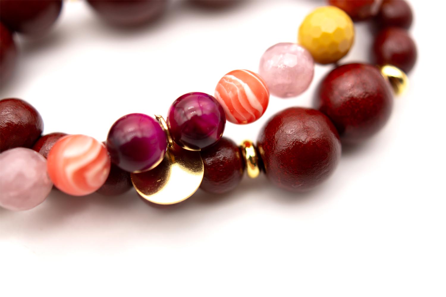 Detailansicht der pink-orange gestreiften und rosa Edelsteinperlen mit goldfarbenem Plättchen