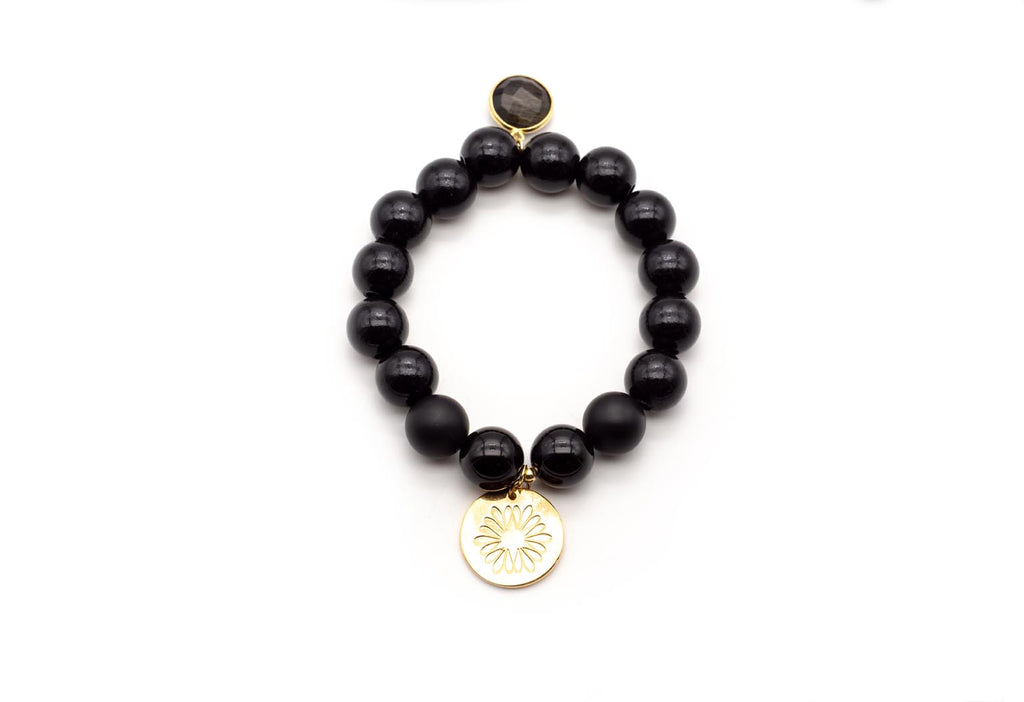 Armband auf Elastikband mit schwarzen Onyx-Perlen, vergoldetem Onyx-Anhänger und Logo-Tag mit Lotusmotiv