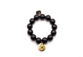 Armband auf Elastikband mit schwarzen Holzperlen, facettiertem Onyx-Anhänger und vergoldetem Logo-Tag