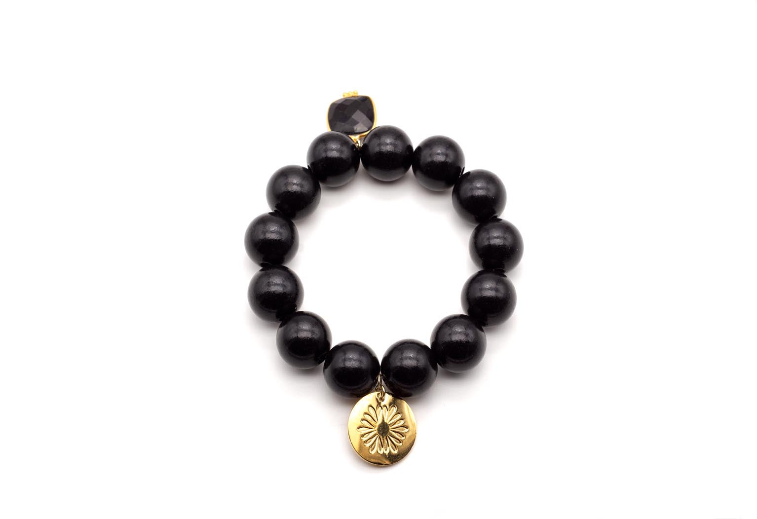 Armband auf Elastikband mit schwarzen Holzperlen, facettiertem Onyx-Anhänger und vergoldetem Logo-Tag