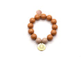 Armband auf Elastikband mit caramelfarbenen Holzperlen, rosa Quarz-Anhänger und vergoldetem Logo-Tag