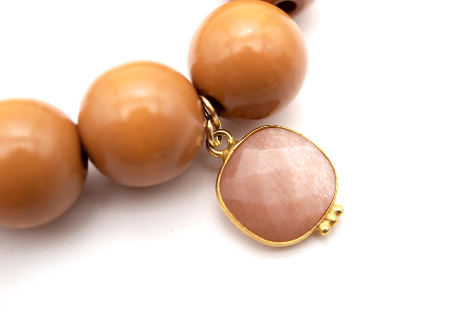 Detailaufnahme des rosa Quarz-Anhängers in vergoldeter Fassung