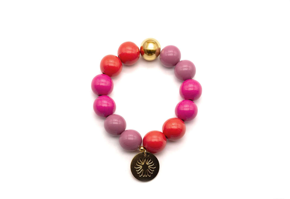 Armband auf Elastikband mit pinken, rosa und roten Holzperlen, vergoldeter Perle und rundem Logo-Tag