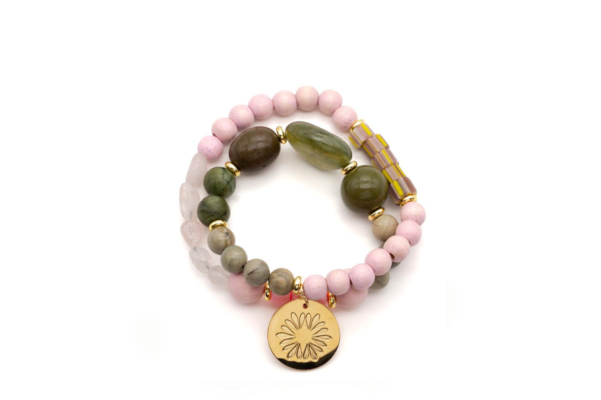 Doppeltes Armband auf Elastikband mit rosa Holzperlen, grünen Edelsteinen und vergoldetem Logo-Tag mit Blütenmotiv
