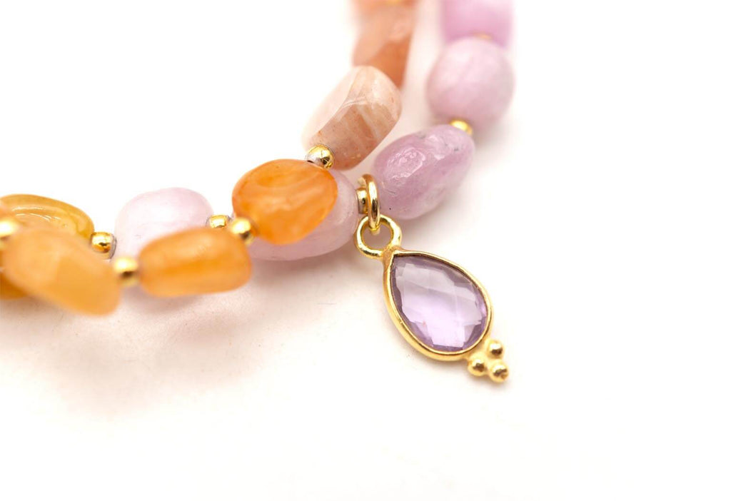Detail des tropfenförmigen Amethyst-Anhängers in goldfarbener Fassung zwischen den Edelsteinperlen
