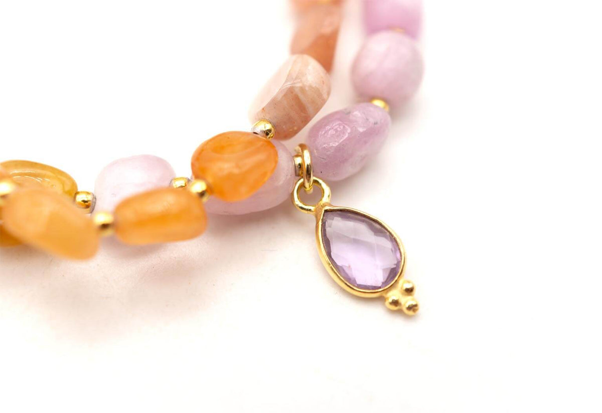 Detail des tropfenförmigen Amethyst-Anhängers in goldfarbener Fassung zwischen den Edelsteinperlen