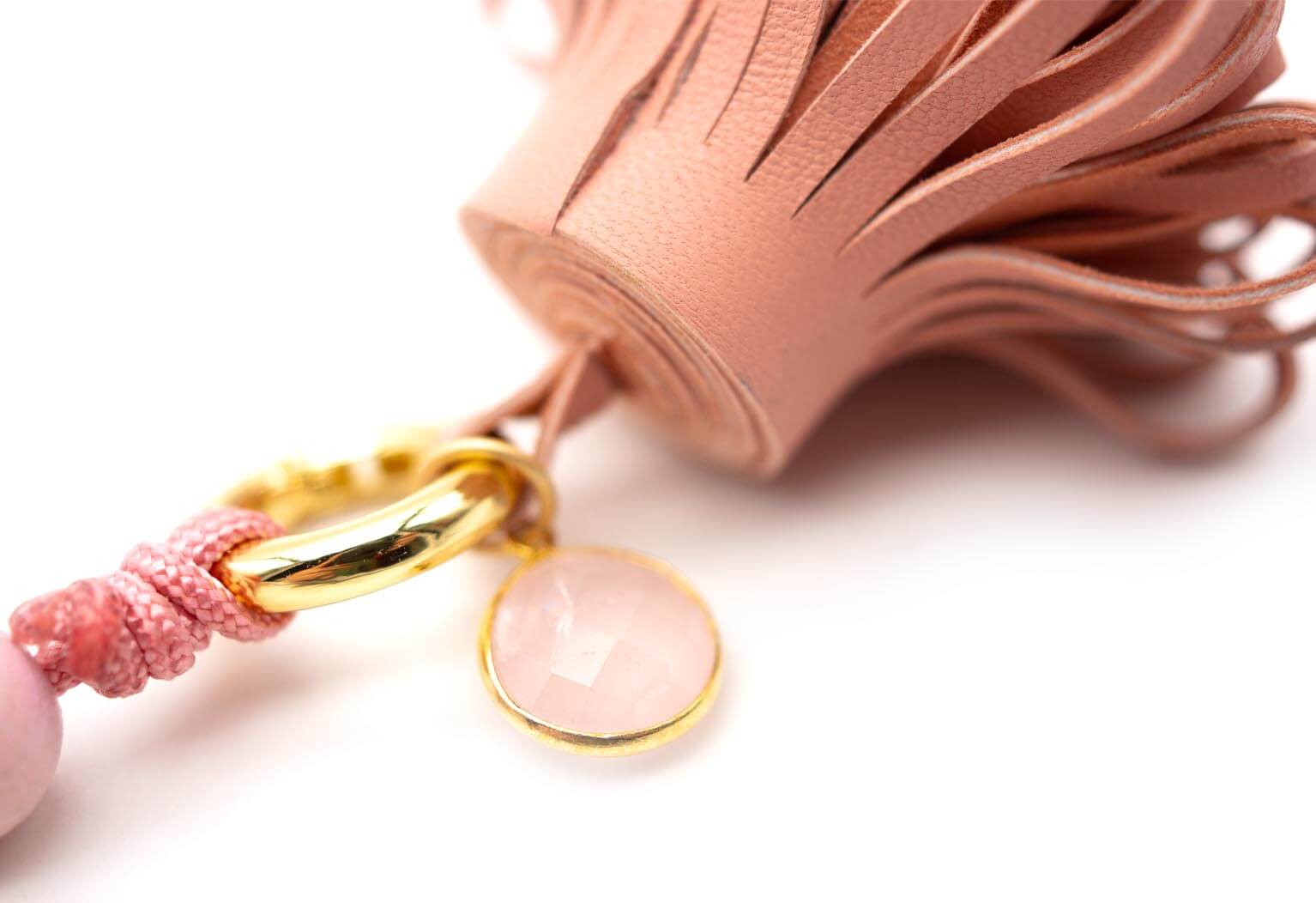 Detail der Nappaleder-Quaste mit facettiertem Rosenquarz-Anhänger in goldfarbener Fassung