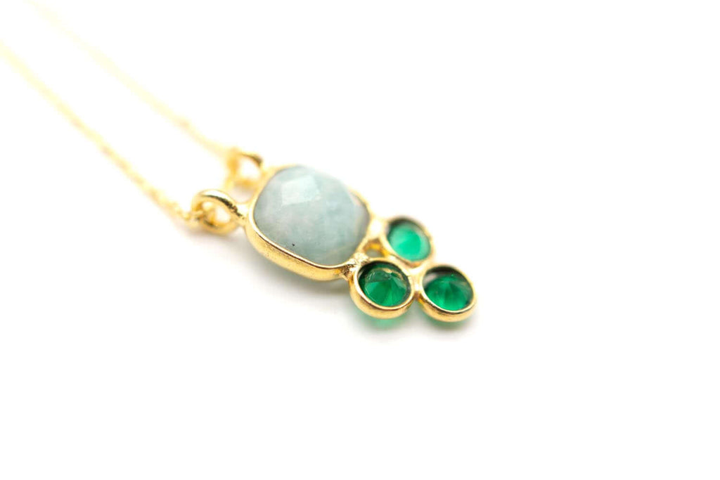 Detailansicht des Anhängers mit milchig blauem Amazonit über drei glänzend grünen Steinen