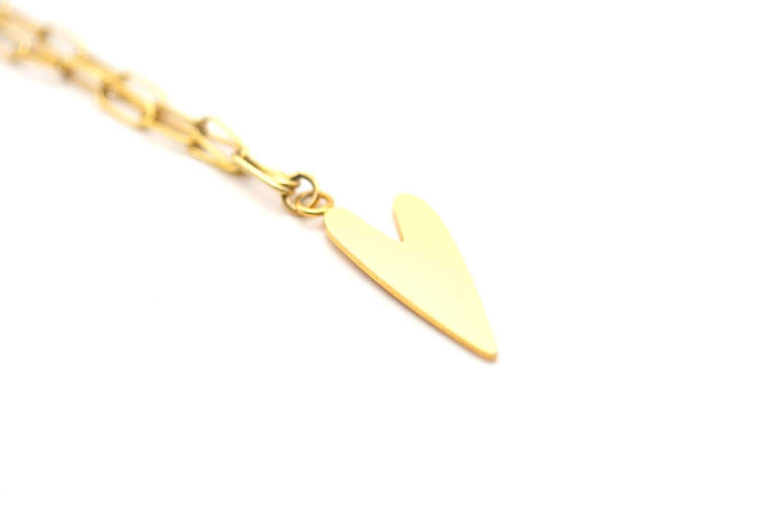 Detailaufnahme des glänzenden Herzanhängers an der Paperclip-Kette