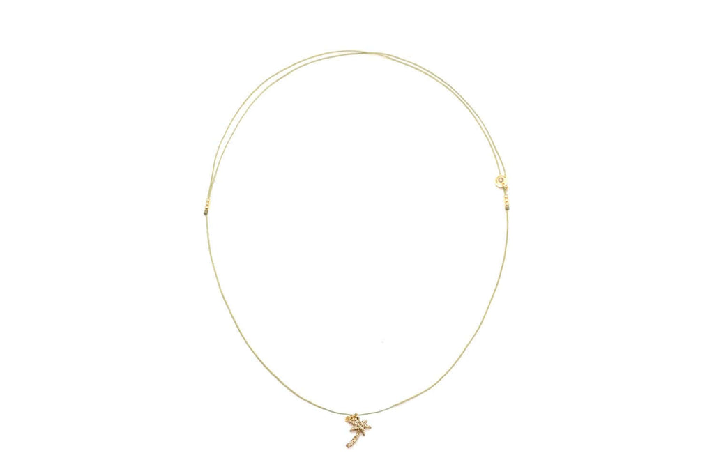 Choker aus grüner Nylonschnur mit goldfarbenem Palmen-Anhänger, freigestellt vor Weiß