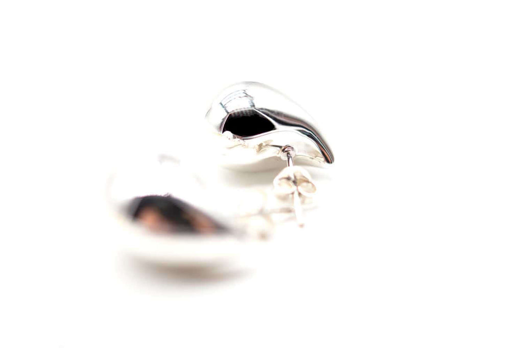 Silberfarbene Tropfen-Ohrstecker in seitlicher Nahaufnahme