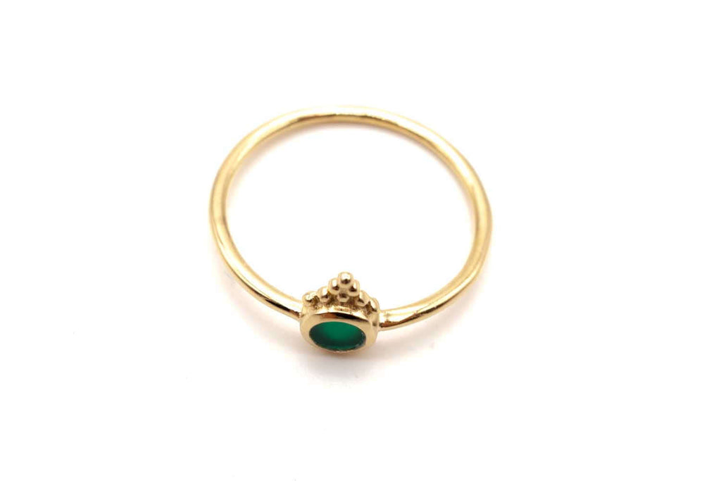 Vergoldeter Ring von oben liegend, Onyx-Stein oval sichtbar
