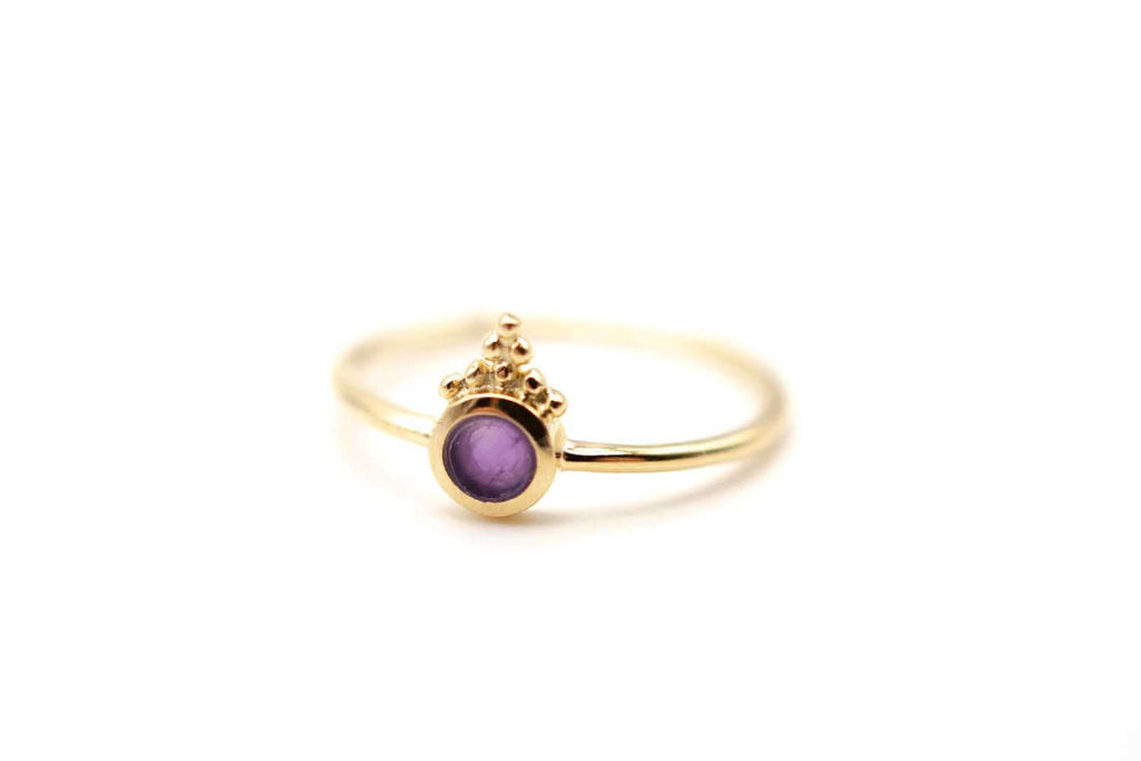 Zarter vergoldeter Ring mit rundem violettem Amethyst und Kügelchen-Verzierung, freigestellt