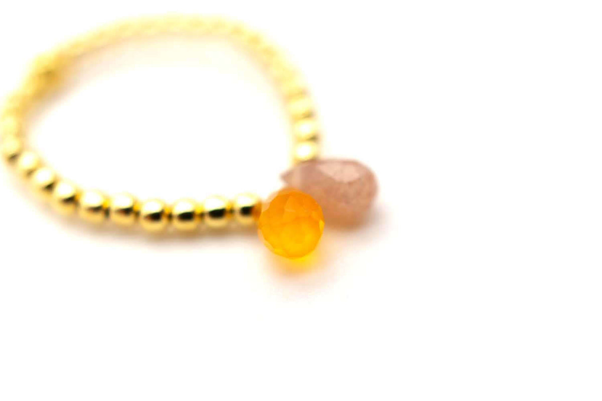 Nahaufnahme der beiden facettierten Tropfen, orange und schimmernd beige