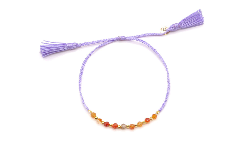 Geflochtenes Macramé-Armband in Flieder mit orangeroten Karneol-Perlen und goldfarbenen Kügelchen, zwei Quasten