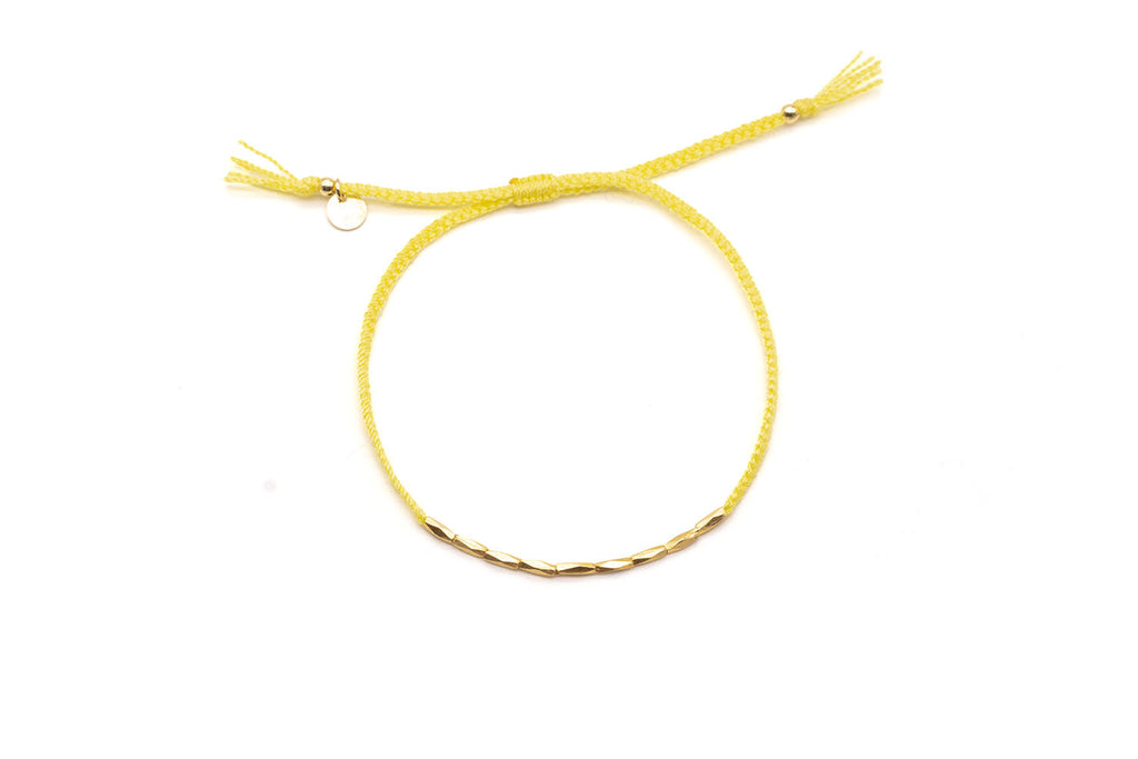 Gelbes geflochtenes Macramé-Armband mit einer Reihe vergoldeter Röhrchen und Zugverschluss