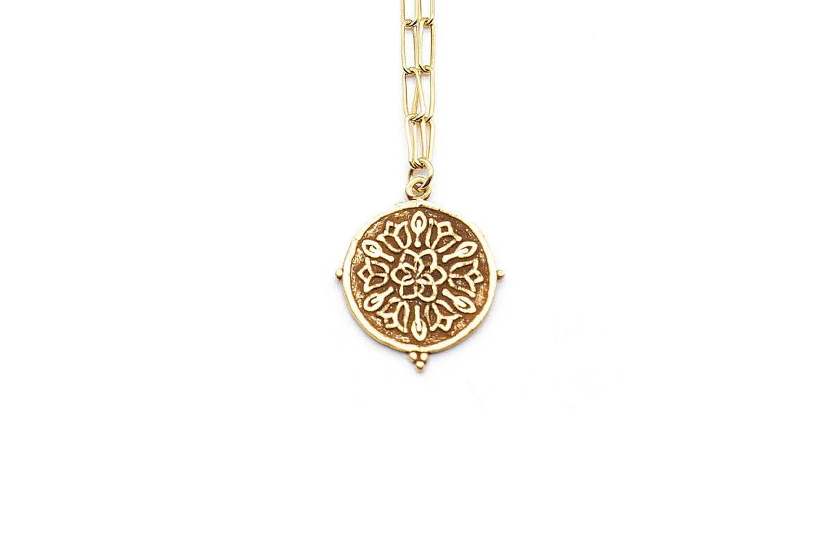 Nahaufnahme des Münzanhängers mit floralem Mandala-Muster