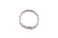 Ring aus kleinen Sterlingsilber-Perlen auf Elastikband, freigestellt vor hellem Hintergrund