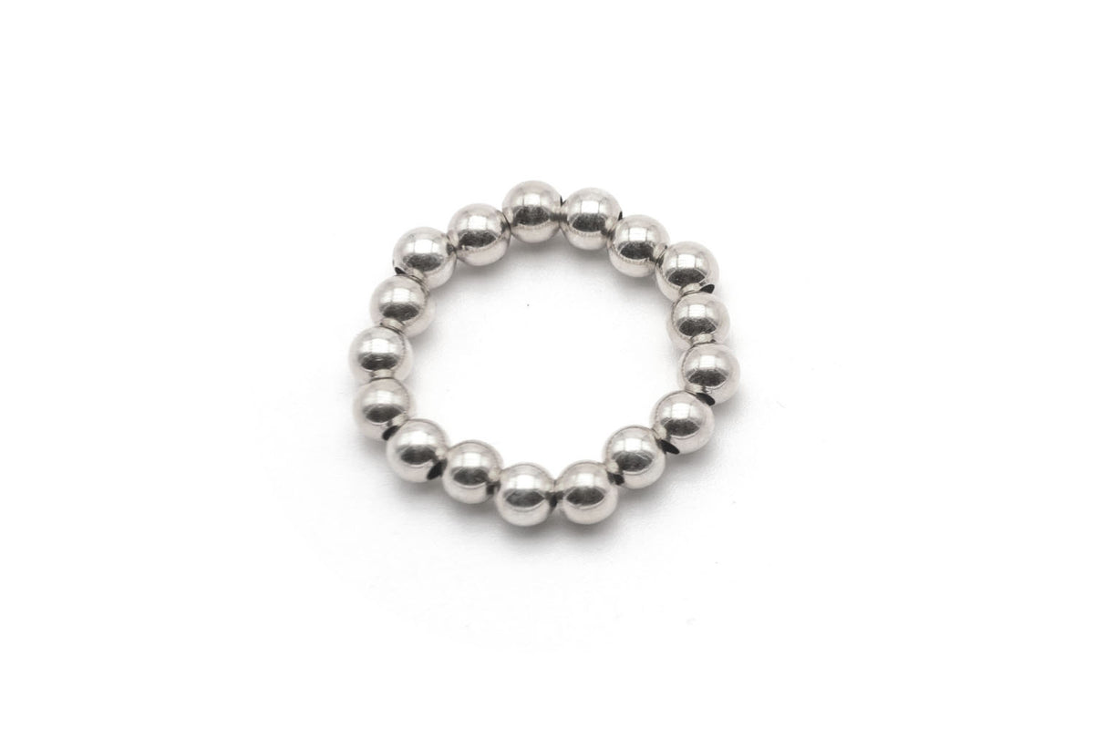 Elastischer Ring aus glänzenden 4-mm-Perlen aus Sterlingsilber, freigestellt vor hellem Hintergrund